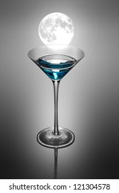 Blue Cocktail In The Martini Glass. White Moon Above.