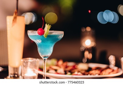 Blue Cocktail On The Glass With The Bbq Food In The Night Dinner Party