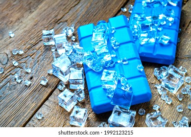 Blue cold accumulators blocks in the ice on a wooden background. Concept of summer tourism. - Shutterstock ID 1992123215