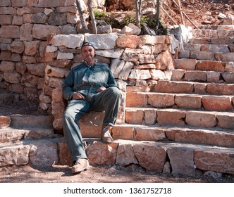 Blue Collar Worker Sitting On Construction