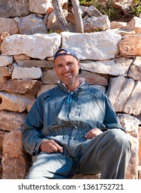 Blue Collar Worker Sitting On Construction