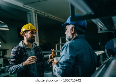 Blue Collar Workers Talking On Lunch Break In Warehouse