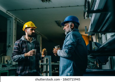 Blue Collar Workers Talking On Lunch Break In Warehouse