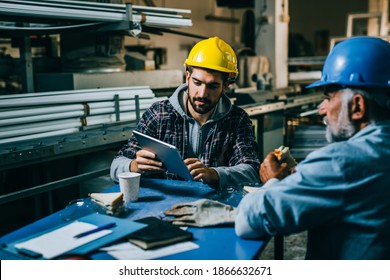 Blue Collar Workers Talking On Lunch Break At Warehouse