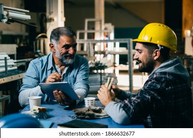 Blue Collar Workers Talking On Lunch Break At Warehouse