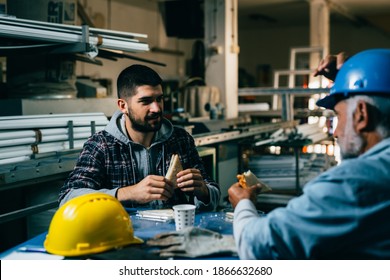 Blue Collar Workers Talking On Lunch Break At Warehouse