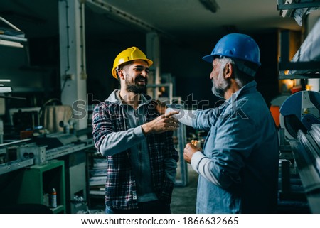 blue collar workers talking on lunch break at warehouse