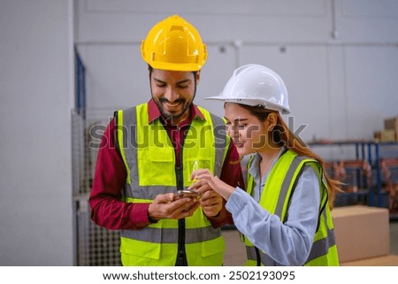 Blue collar workers are using smart phone at warehouse. Industrial and factory.