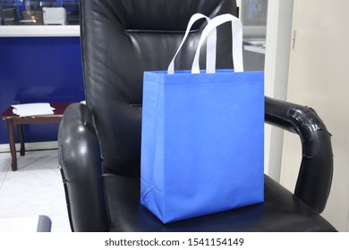 Blue Color Non Woven Bag On Black Chair Polypropylene Bag Eco Friendly Bag, Colorful Gift And Shopping Bag