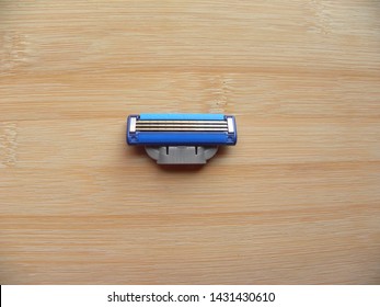 Blue Color Shaving Razor Blade Cartridge Kept On Wooden Table