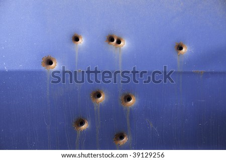 Blue coloured pontiac that has been shot nine times.