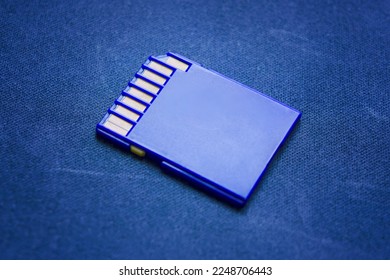 Blue compact memory card for camera in closeup. Blue Secure Digital Memory Card Back side of digital media with contact tracks Isolated blue background 