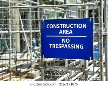 Blue Construction Area No Trespassing Sign Hang On Metal Fence Of Construction Site.