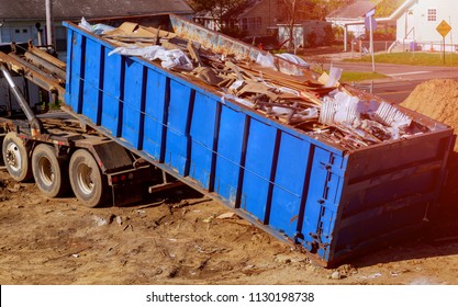 Blue construction debris container filled with rock and concrete rubble. Industrial garbage bin - Powered by Shutterstock