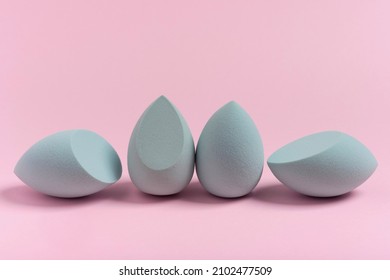 Blue cosmetic makeup sponge on a minimal pink background. A set of sponges of different shapes. Tool for applying foundation cream. Nobody.