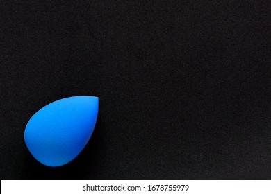 Blue cosmetic sponge on a black background.  Top view