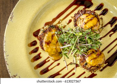 Blue Crab Cakes Topped With Roasted Tomato Basil Aioli And Micro Green With Balsamic Glaze Shot From Above