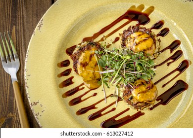 Blue Crab Cakes Topped With Roasted Tomato Basil Aioli And Micro Green With Balsamic Glaze And Wooden Fork Shot From Above