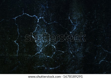 Blue cracks on a black plaster background