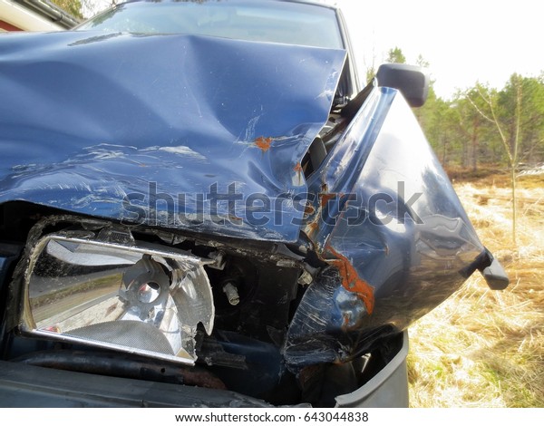 Blue\
crashed car with damaged left light and front\
boot