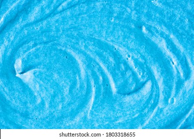 Blue Cream Texture. The Surface Of Berry Yogurt And A Smoothie Of Whipped Cream. Background Texture Of Masks And Scrubs For Face And Body. Pearlescent Silver Surface Of Blue Foam.