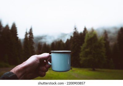 Blue Cup In Hands With Forest Background. Cinematic Travel Inspirational Background. Focus On Cup