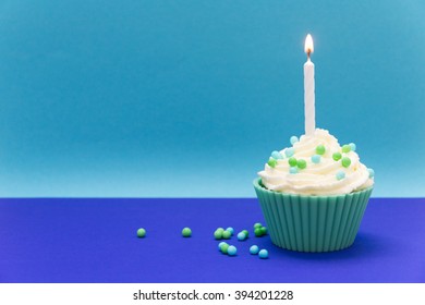 Blue Cupcake With Candle And Blue Colored Background