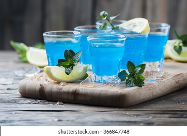 Blue Curacao Liqueur With Lemon On The Wooden Table, Selective Focus