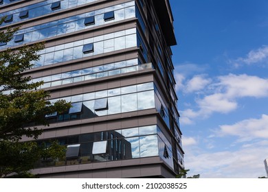 Blue Curtain Wall Made Of Toned Glass And Steel Constructions Under Cloudy Sky