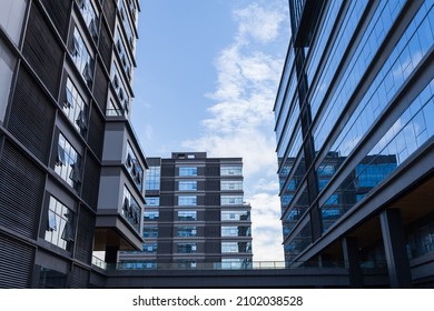 Blue Curtain Wall Made Of Toned Glass And Steel Constructions Under Cloudy Sky