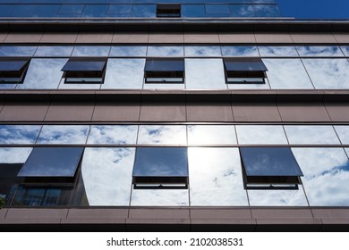 Blue Curtain Wall Made Of Toned Glass And Steel Constructions Under Cloudy Sky