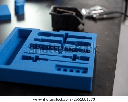 Blue custom foam insert with precision cut compartments for tool and equipment organization in protective case