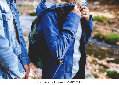 Blue denim jacket and parka. Clothing for the camping trip. Hiking clothes. Two young girls friends walking in the autumn forest. Walk in the woods at fall.