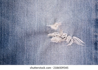 Blue Denim Jeans Tear Surface. Old Fabric Damaged Detail Texture Background.