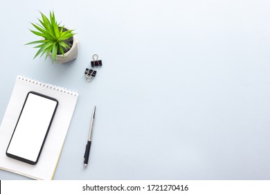 Blue desk office with laptop, smartphone and other work supplies with cup of coffee. Top view with copy space for input the text. Designer workspace on desk table essential elements on flat lay