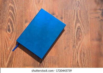 blue diary on the table. book on a wooden background. notebook lies on the floor - Powered by Shutterstock