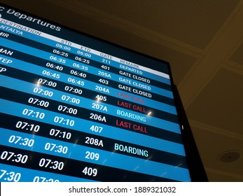 A Blue Digital Screen At An Airport Announcing Time And Gate Info For Each Flight. Messages Are: LAST CALL, BOARDING And GATE CLOSED