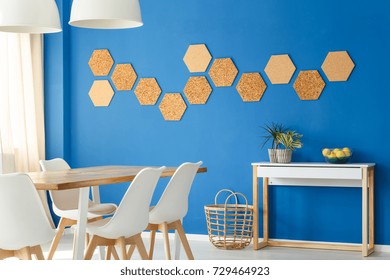 Blue Dining Room With Cork Wall Decor And Basket On Floor Next To Simple Cupboard