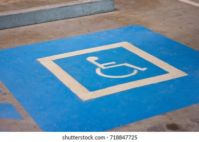 Blue Disabled Parking Sign Painted On Dark Asphalt.Universal Sign For Handicap Parking Spot I