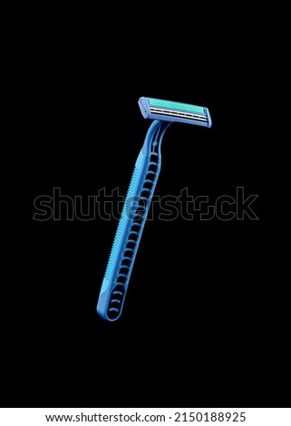 Blue disposable razor blade isolated on black background. Single use razor blade.
