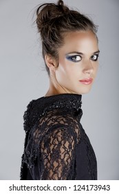 Blue Dramatic Eyeshadow Eye Make-up Trend With Hair In The Messy Top Knot On A Beautiful Young Woman Wearing A Lace Blouse