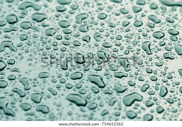 Blue Drops of\
Rain or Water Drop on the Hood of the Car. Rain Drops on the\
Surface of the Car or on the Iron Surface Flow Down. Abstract\
Background and Water Texture for\
Design.