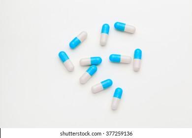 Blue drug pills on white table