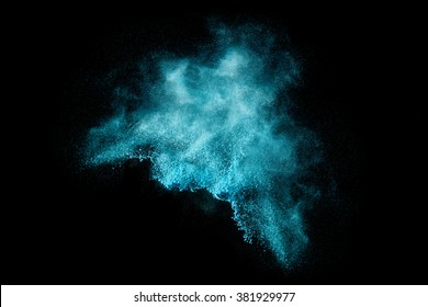 Blue Dust Particle Explosion Resembling Snow Or A Pyrotechnic Effect Over Black. Closeup Of A Color Explosion Isolated On Black