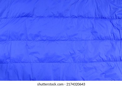 Blue Duvet Covering Texture Background, Soft Surface Of Dark Blue Bedding Quilt Cloth (or Winter Jacket) With Horizontal Stitch And Creased, Close-up Top View