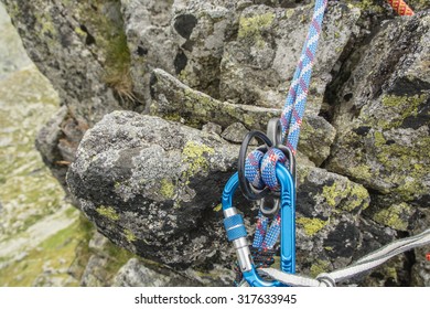 Blue dynamic rope in rappel device in mountains - Shutterstock ID 317633945