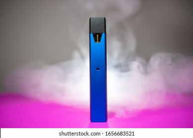 Blue Electric Cigarette Pod ( E Cig ) Is A Pen Style. On Pink Ground With Smoke