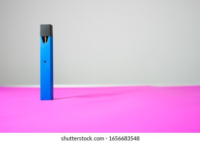 Blue Electric Cigarette Pod Or E Cig Pod Pen Style At The Left Side . On Pink Ground