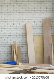 Blue Electric Drill Were Left Aside During Lunch Time Brake. A Desk Full Of Hand Tools And Wood Piles. Work Atmosphere In The Workshop Room.