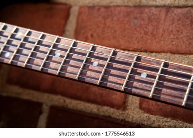 Blue Electric Guitar Against Brick Wall Outside Music Venue